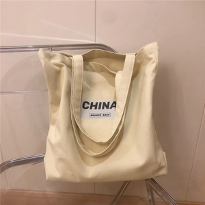 Gros plan du sac fourre-tout en toile épaisse beige avec lettrage CHINA noir
