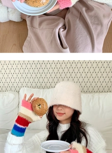 Détail du chapeau en fausse fourrure blanche et des mitaines en tricot à rayures colorées