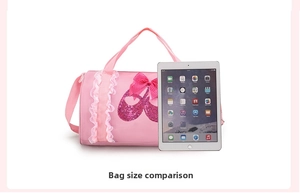 Detailed view of pink sequin ballet shoes on a barrel dance bag next to a tablet