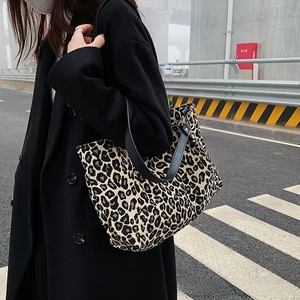 Outdoor shot of a large leopard print canvas tote bag with black shoulder straps