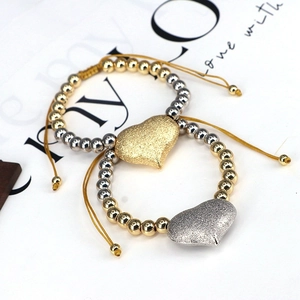 Detail showing gold and silver beads with a matte heart pendant on an adjustable cord