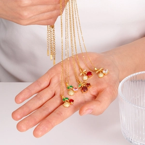 Chic cherry pendant necklace with red zircon and green leaves on a gold chain