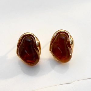Detail von Vintage-Ohrringen aus bernsteinfarbenem Harz mit goldener Lavastruktur