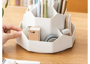 Close-up of a hand rotating the white tiered desktop organizer for office stationery