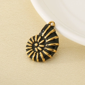 Détail du pendentif nautile en acier inoxydable 304 noir et or sur un tissu en lin beige