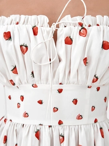 Detail view of floral sundress featuring red strawberry print and drawstring neckline