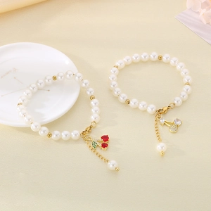 Close-up of pearl bracelets featuring sweet cherry charms with sparkling inlaid crystals