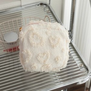 Trousse à maquillage pelucheuse à motif cœur avec fermeture éclair rose sur étagère