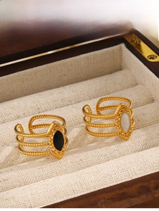 Detail of vintage gold-plated rhombic open rings with braided bands and black/white inlay