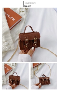 Detail view of mini brown satchel featuring gold buckles and a metallic chain strap