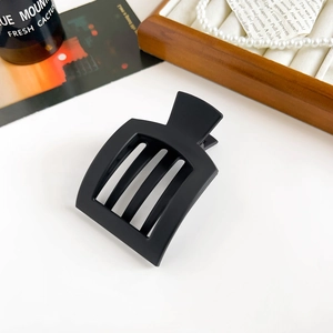 Macro shot of matte black square hair claw clip with vertical hollowed lines for women
