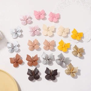 Flat lay of colorful synthetic leather butterfly hair clips on a white lace mat