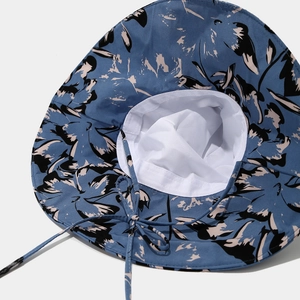 Détail d'un chapeau de soleil bleu à motif floral avec cordon de serrage réglable
