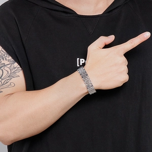 Detail of 15mm wide stainless steel watch strap style link bracelet on a male wrist