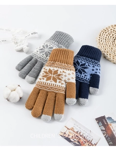 Close-up of thick knitted winter gloves with snowflake patterns and touchscreen fingertips