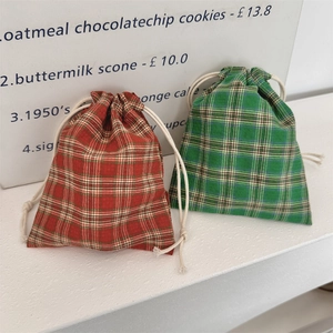 Detailed view of red and green plaid drawstring pouches made of textured cotton linen