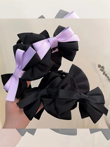 Detailed view of handmade satin bow hair claw clips in solid black and purple colors