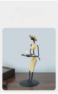 Détail d'un bougeoir en fer vintage avec robe à fleurs jaunes sur une table en bois