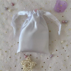 Detailed view of white satin drawstring pouch with silky texture for gift packaging