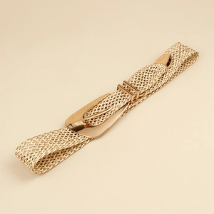Detailed close-up of woven gold elastic belt featuring a smooth polished metal buckle