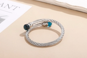 Detail of silver twisted cable bracelet featuring blue faceted crystal end beads