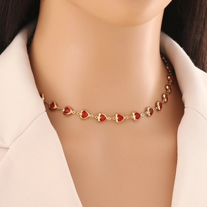 Close-up of heart-shaped red gemstone necklace on neck with gold plated finish