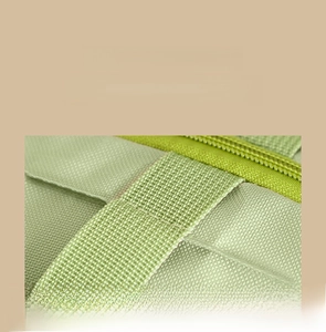 Close-up of sturdy reinforced stitching and durable zipper on green quilt storage bag