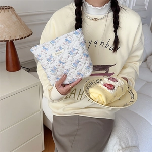 Quilted cotton makeup bag featuring blue bow bears and floral patterns in hand