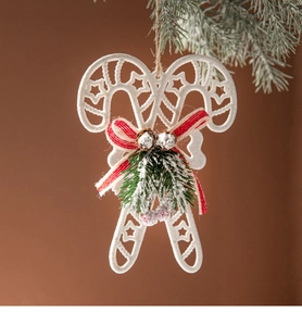 Detail of Christmas candy cane hanging ornament with white stars and pine cone decor