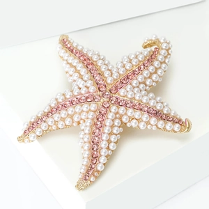 Detailed macro view of starfish brooch with pearls and pink crystals in a gift box