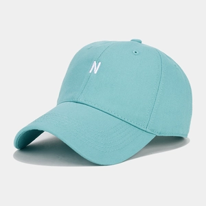 Close-up of white letter N embroidery on light blue-green cotton twill baseball cap