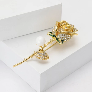 Vintage rose brooch with sparkling rhinestones and white pearl on white display stand