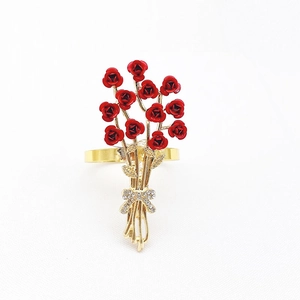 Detail of red rose napkin ring with golden bow and sparkling rhinestones on white backdrop