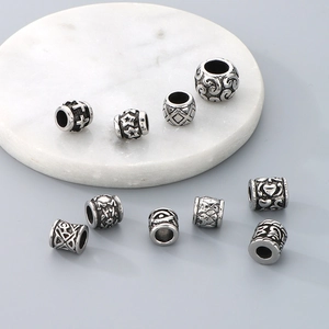 Close-up of vintage engraved stainless steel spacer beads with various patterns for DIY jewelry