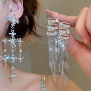 Detailed shot of long silver tassel earrings with crystals and white pearls for women