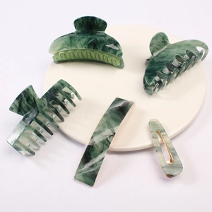 Five-piece green marble pattern hair clip set including claw clips and barrettes on a tray