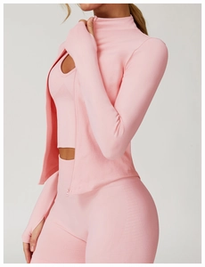 Détail de l'ensemble de yoga côtelé rose avec poignets passe-pouce et col montant zippé