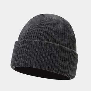 Close-up of thick ribbed knit texture on a dark charcoal winter beanie with rolled cuff