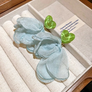 Detail of floral tassel earrings with blue tulle petals and green heart resin studs