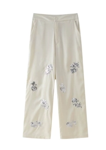 Detailansicht der cremefarbenen High-Waist-Hose mit silberner Pailletten-Blumenstickerei