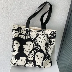 Close-up of minimalist canvas tote bag featuring black hand-drawn artistic face patterns