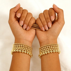 Layered 18K gold plated beaded stretch bracelet set with glossy metal finish