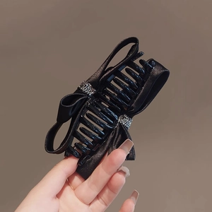 Detail of a large black satin bow hair claw clip with rhinestones and sturdy teeth