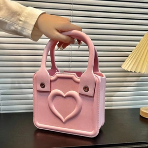 Pink EVA handbag detail with embossed heart pattern and textured synthetic leather finish
