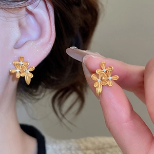 Close-up of 24K gold plated flower stud earrings with zircon inlay and matte finish