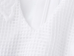 Detail of white mesh fabric with V-neckline and invisible zipper on elegant dress