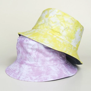 Détail de chapeaux bobs tie-dye jaune et violet montrant les coutures du bord