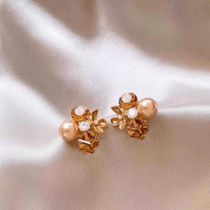 Close-up of vintage flower earrings with amber crystals and champagne pearls on silk