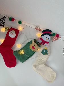 Close-up of festive Christmas cotton socks featuring Santa, reindeer, and tree patterns