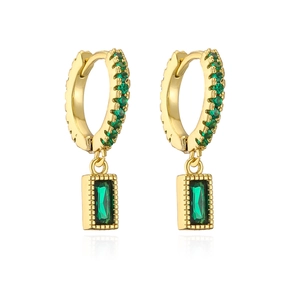 Dettaglio di orecchini huggie dorati con pendenti in zircone verde e bordi milgrain